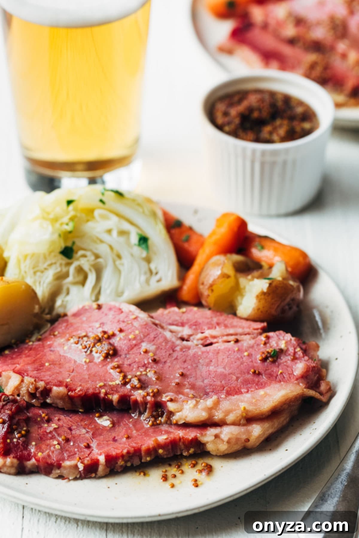 sliced corned beef on an ivory ceramic plate with potatoes, carrots, and cabbage