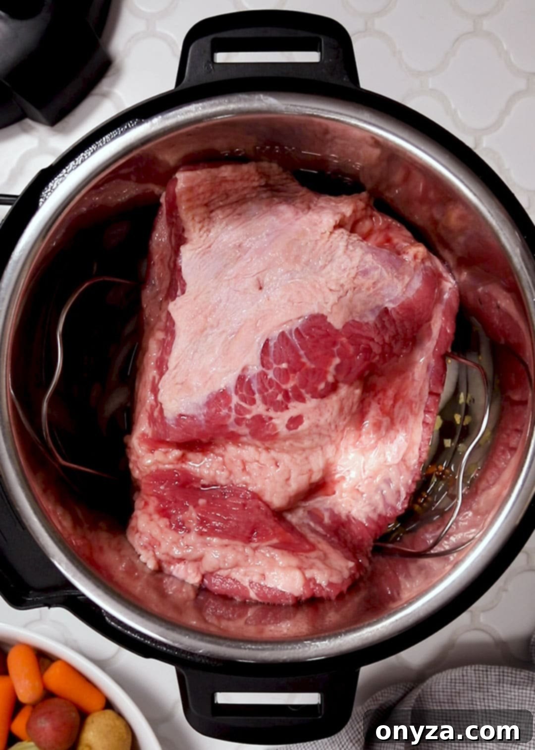 uncooked flat cut corned beef brisket on a trivet in an Instant Pot