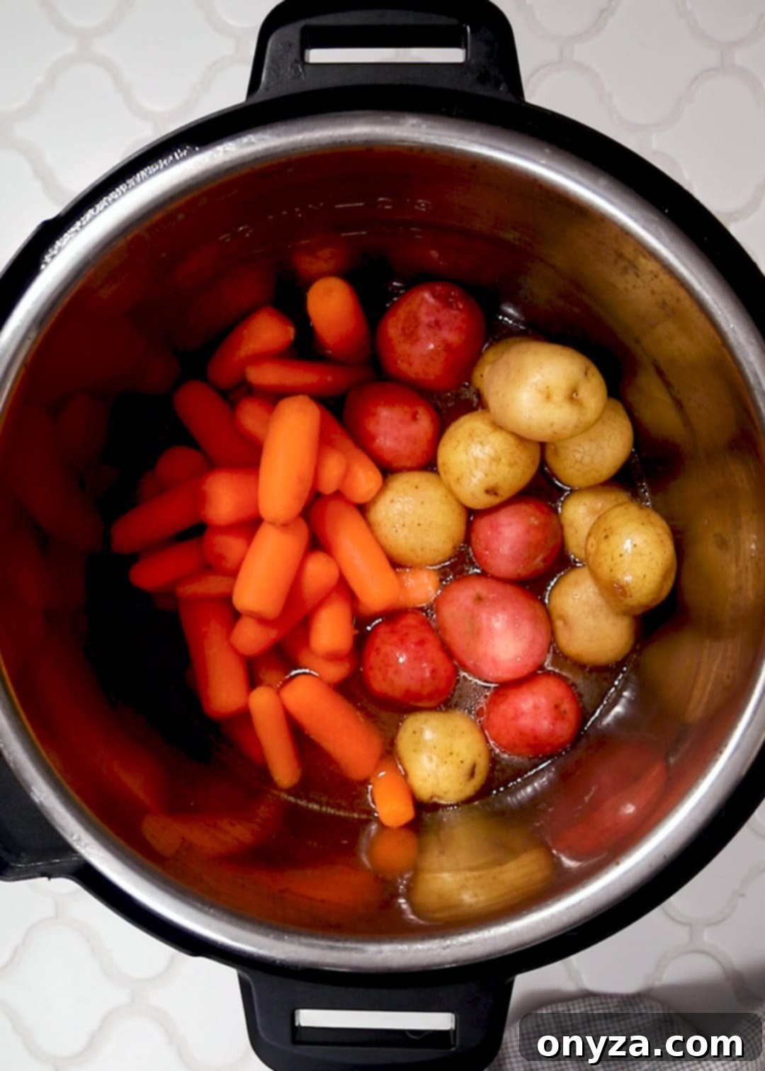 uncooked baby carrots and creamer potatoes in an instant pot
