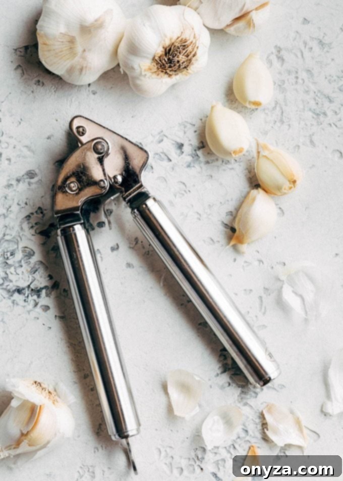 garlic cloves and a garlic press for scampi recipe