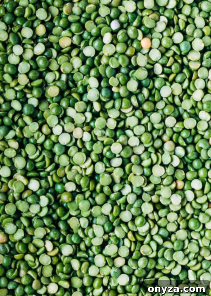 Close-up view of a pile of dried green split peas, showcasing their distinct split halves and vibrant color.