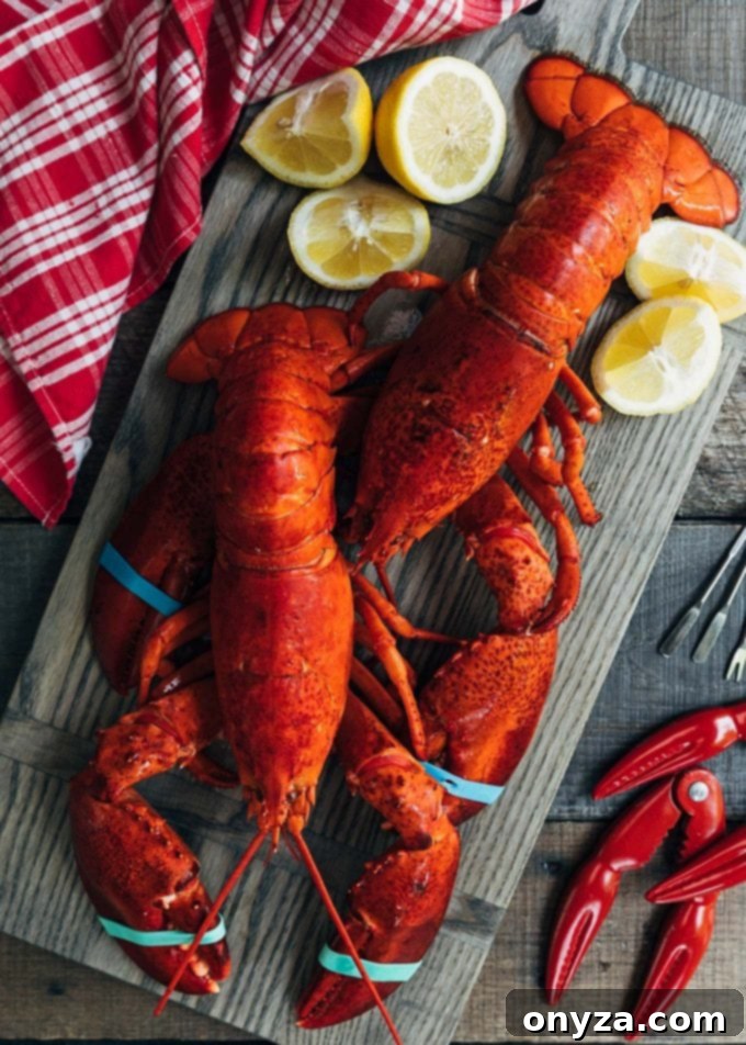 Freshly steamed whole lobsters arranged on a rustic wooden board, garnished with bright lemon wedges, ready for cracking and preparing into a delicious meal.