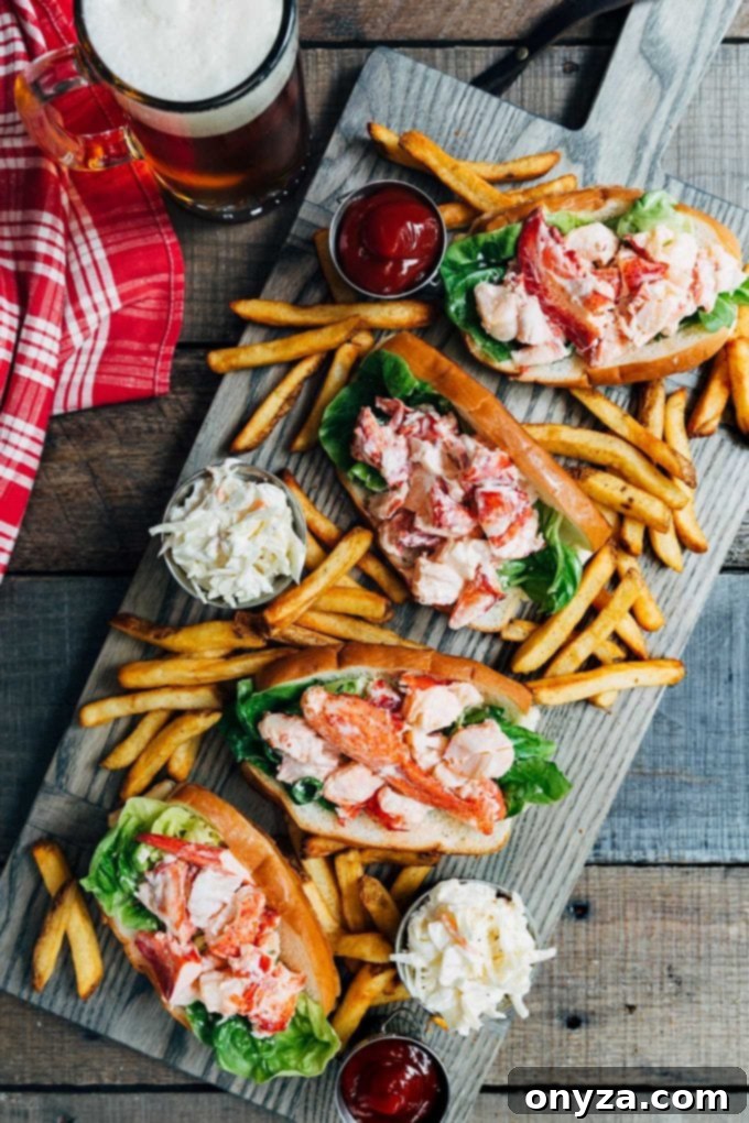 A beautifully presented Maine lobster roll served on a rustic board, accompanied by crispy french fries and a side of fresh coleslaw, embodying a perfect summer feast.