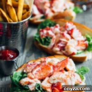 maine lobster rolls on a wood board with french fries