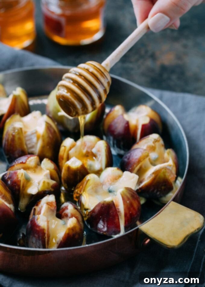 Drizzling golden honey over warm, baked Cambozola stuffed figs, garnished with toasted walnuts