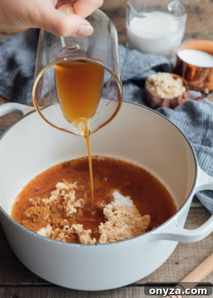 Fresh apple cider being poured into a heavy-bottomed pot, ready for reduction to make boiled cider.