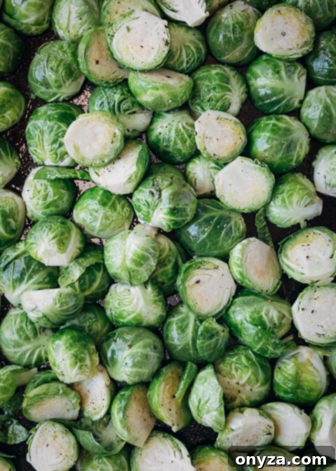 A close-up of halved Brussels sprouts neatly arranged on a baking pan, ready for the oven to achieve perfect roasting.