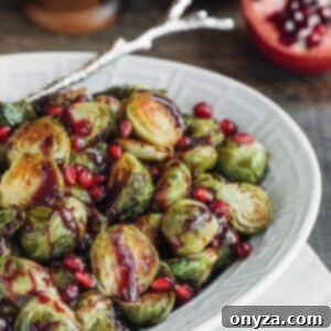 roasted brussels sprouts with pomegranate in a white serving dish