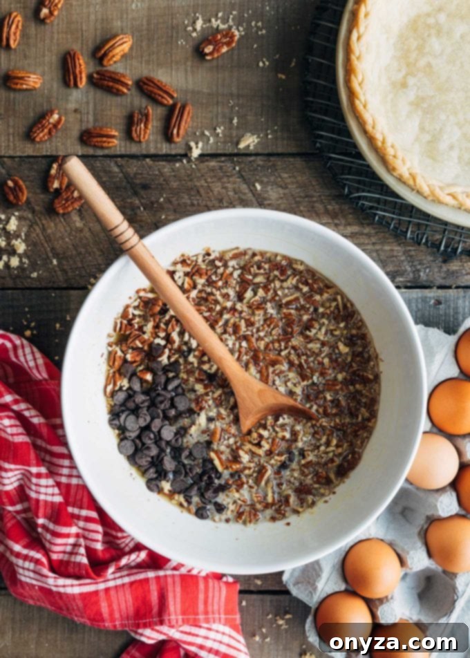 ingredients for chocolate pecan pie with bourbon in a white bowl with a wooden spoon