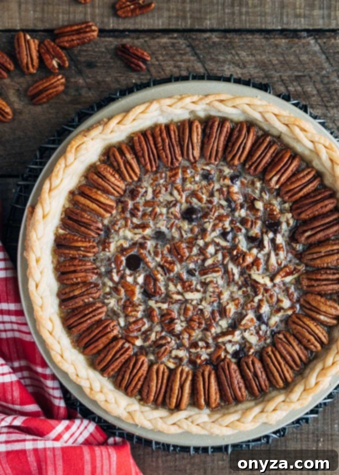 unbaked chocolate pecan pie on a wood board with a red plaid napkin