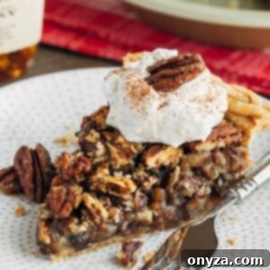 slice of chocolate pecan pie on a plate with whipped cream