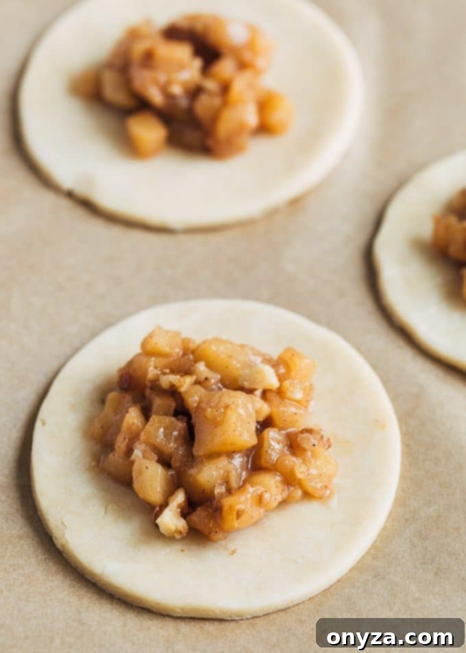 Caramel apple hand pie filling artfully placed on a round of flaky pie dough, ready for assembly