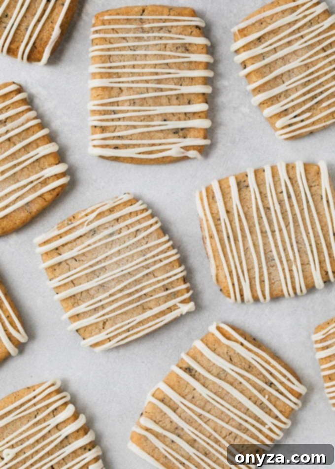white chocolate drizzled shortbread cookies on a baking sheet