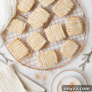 chai spice shortbread cookies with white chocolate drizzle on a cooling rack