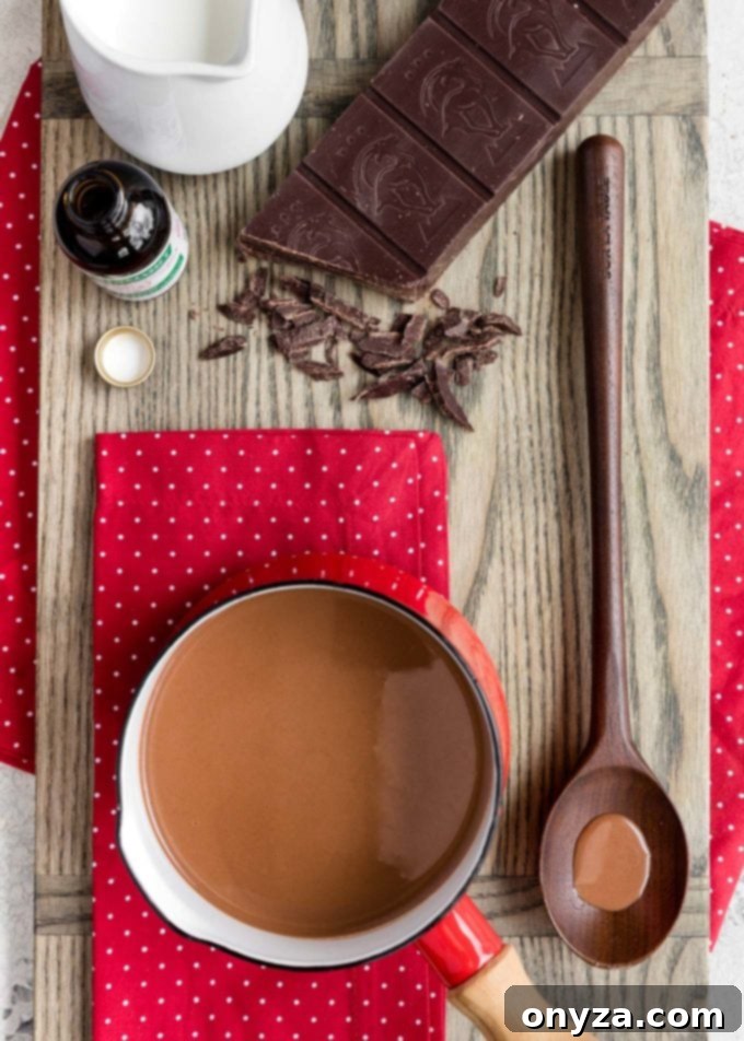 pot of peppermint hot chocolate on a board with a block of semisweet chocolate and a pitcher of milk