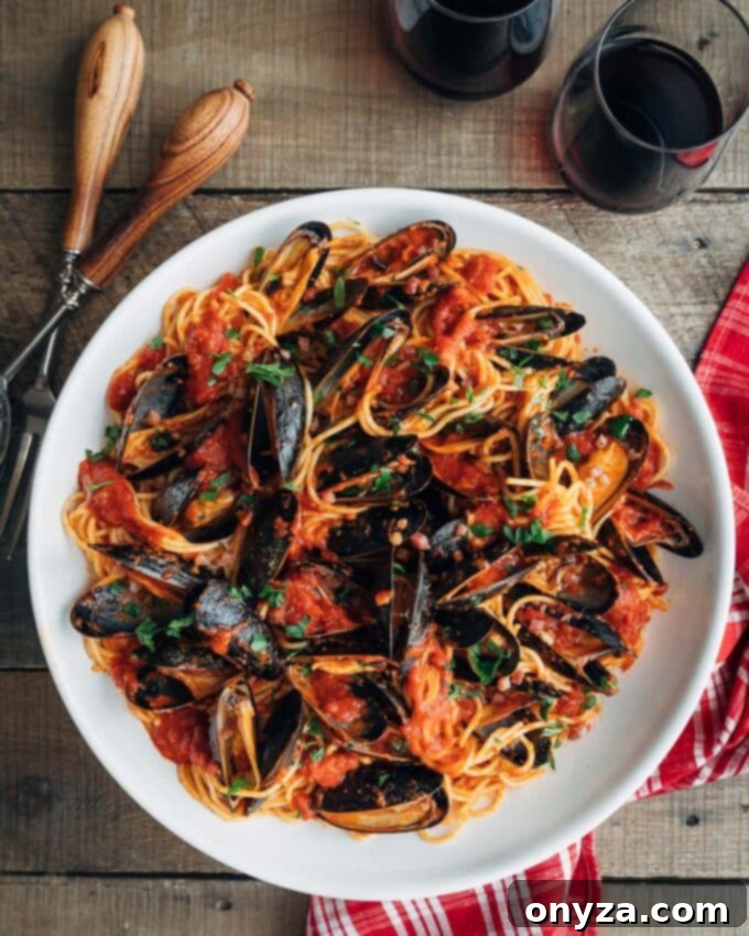 San Marzano Mussel Pasta 2 Mouthwatering pasta with mussels and vibrant San Marzano tomato sauce in a white serving bowl
