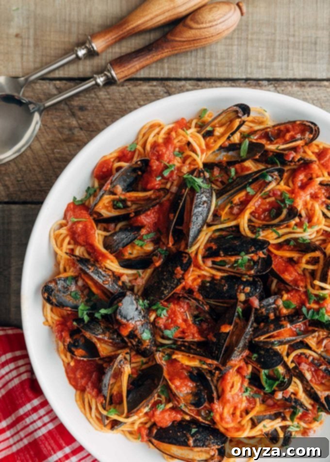 San Marzano Mussel Pasta 5 Overhead view of a delightful serving of pasta with mussels and San Marzano tomato sauce in a white bowl