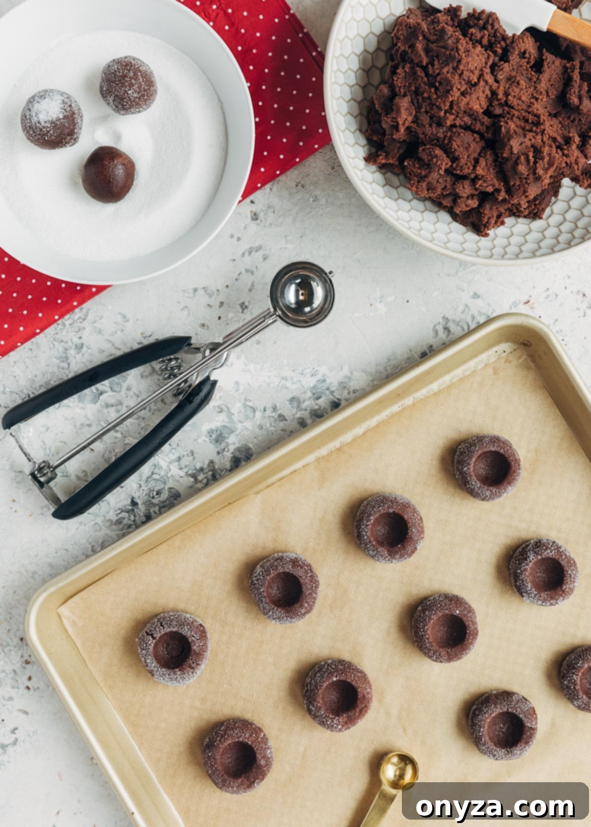 chocolate thumbprint cookie dough scooped onto a baking sheet