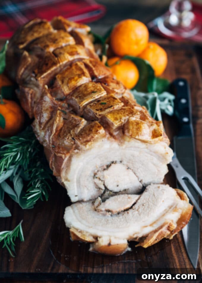 Perfectly Crispy Porchetta 2 Porchetta roast with a slice cut on a wood board, showcasing crispy skin and juicy meat.