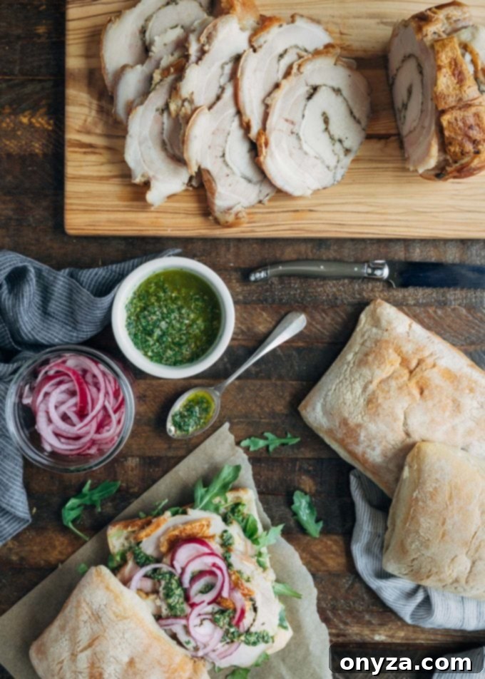 A rustic wooden board showcasing the essential ingredients for creating authentic Italian porchetta sandwiches: sliced red onion, fresh parsley, capers, lemon, garlic, anchovies, and a bottle of olive oil.