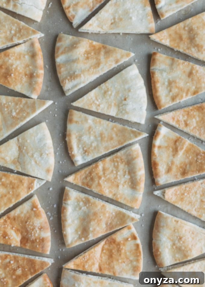 unbaked pita chips with a generous sprinkle of sea salt, laid out on a baking sheet