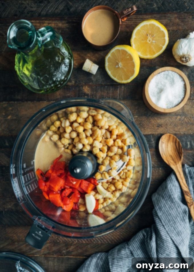 chickpeas, roasted peppers, tahini, and garlic in a food processor bowl for hummus