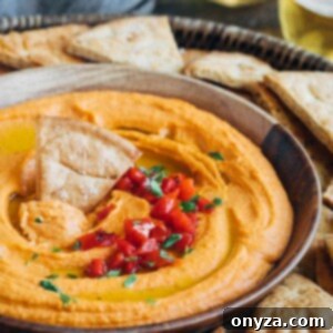 roasted red pepper hummus in a serving bowl with pita chips