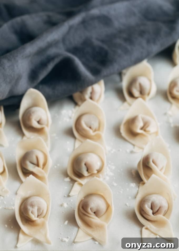 folded wontons on a parchment lined baking sheet