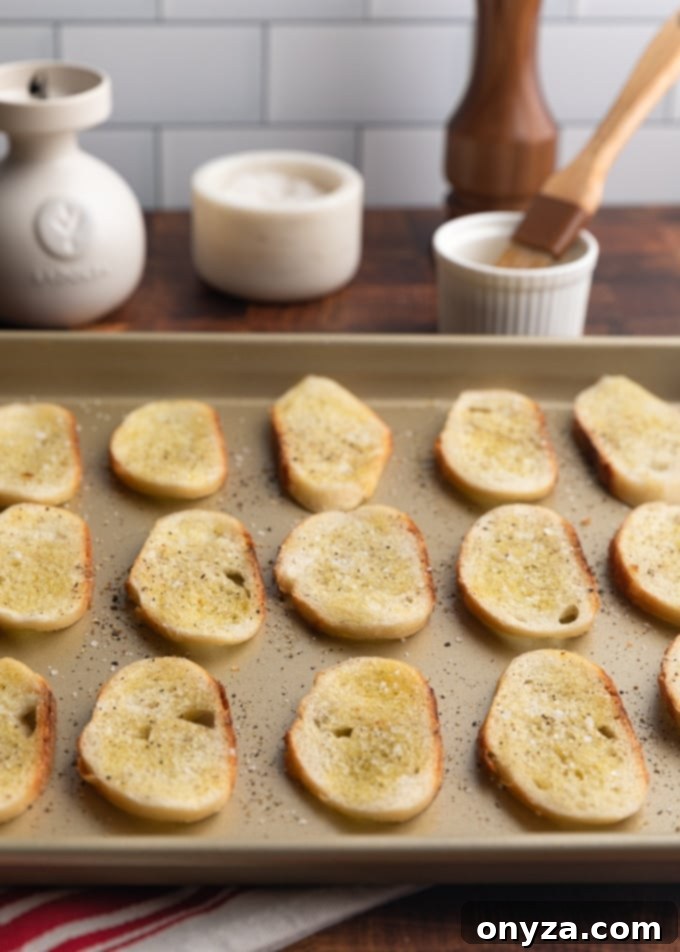 pan of crostini toasts with olive oil, salt, and pepper