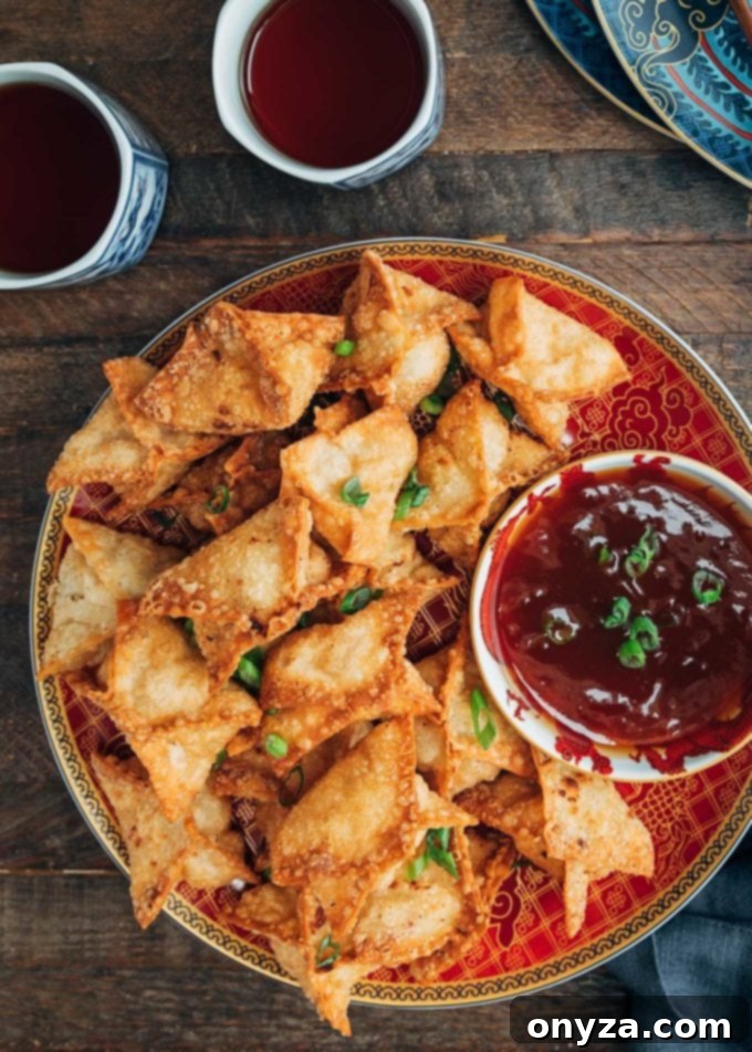 crab rangoon with sweet and sour dipping sauce on a red plate
