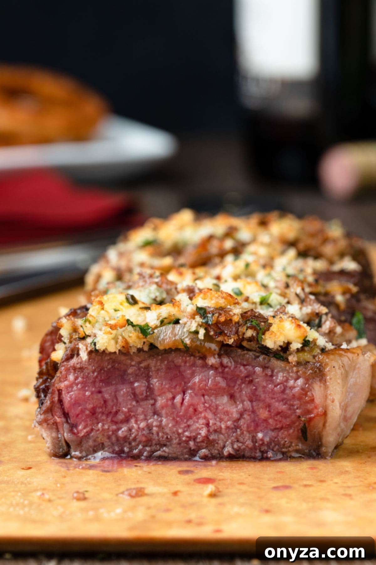 Balsamic Shallot Steak with Blue Cheese Crust 9 blue cheese crusted new york strip steak on a cutting board