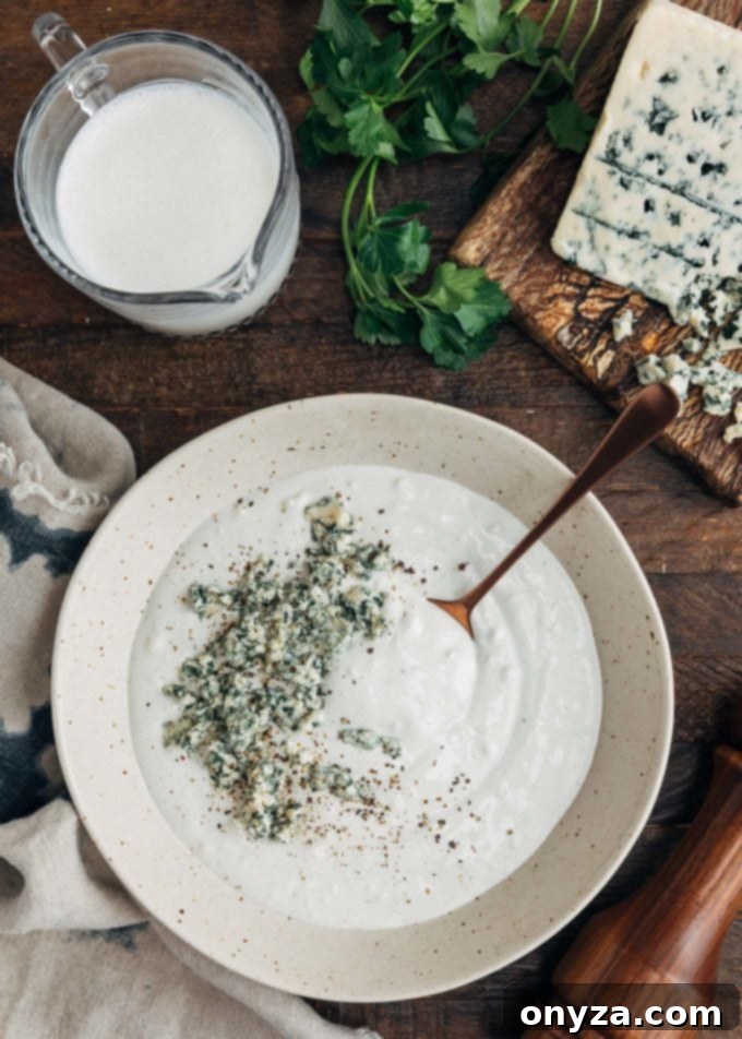 Creamy Buttermilk Blue Cheese Dressing 3 Close-up of crumbled blue cheese sprinkled on top of a bowl of freshly made blue cheese dressing.