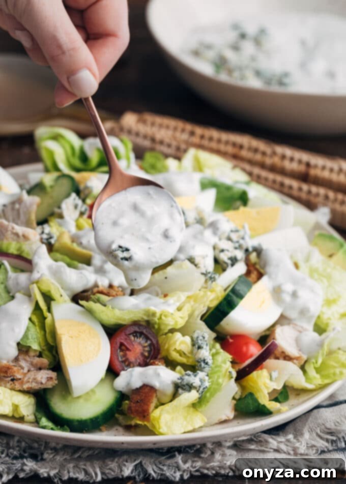 Creamy Buttermilk Blue Cheese Dressing 5 Thick, creamy homemade blue cheese dressing being generously drizzled over a fresh house salad.