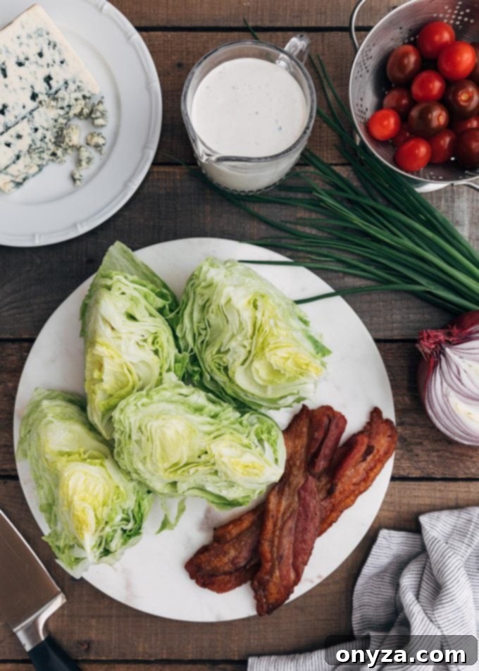 Individual wedges of crisp iceberg lettuce, alongside generous crumbles of blue cheese and freshly cooked, crispy bacon bits, meticulously arranged for assembling a delicious Wedge Salad.