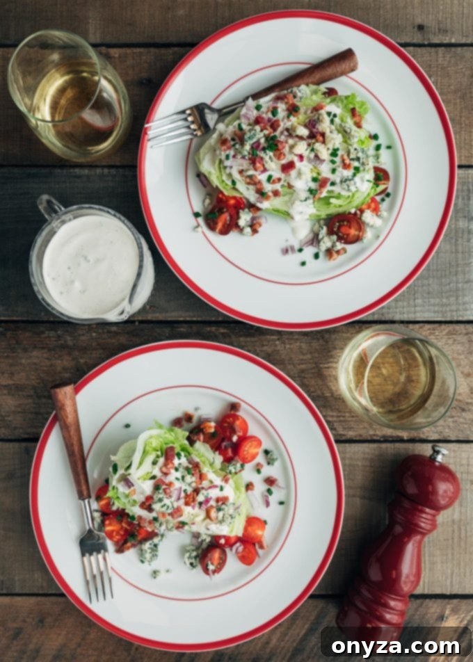 Overhead view of multiple perfectly plated Classic Wedge Salads, each generously topped with creamy blue cheese dressing, crispy bacon, and fresh tomatoes, elegantly served on white dishes, ideal for entertaining.