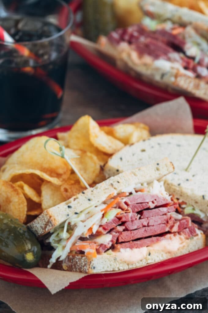 Classic corned beef sandwich with coleslaw and Russian dressing on rye bread, cut in half