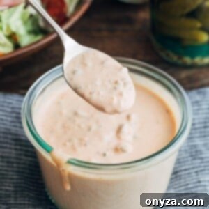 spoonful of an easy homemade Russian dressing recipe over a glass storage jar