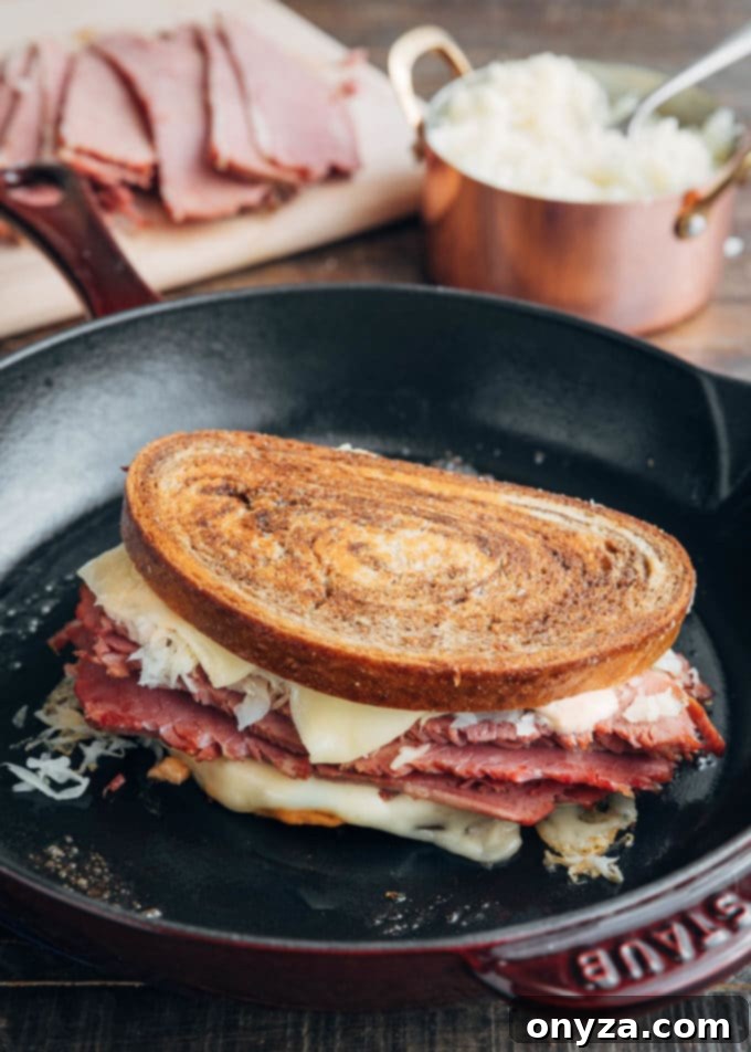 Homemade Reuben Sandwich Perfection 4 A grilled Reuben sandwich sizzling in a Staub cast iron skillet, golden-brown and perfectly melted