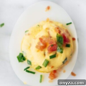 Zesty Horseradish Bacon Deviled Eggs 6 bacon deviled egg with horseradish and chives on a marble board