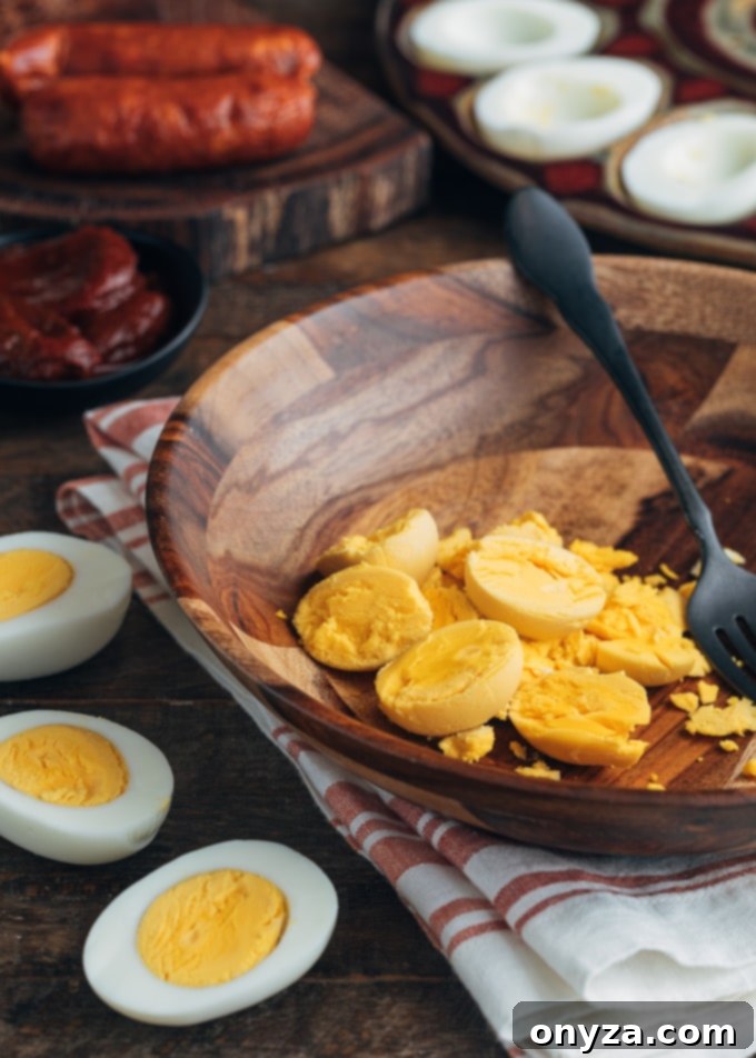 hard boiled egg yolks in a wooden bowl and halved hard cooked eggs