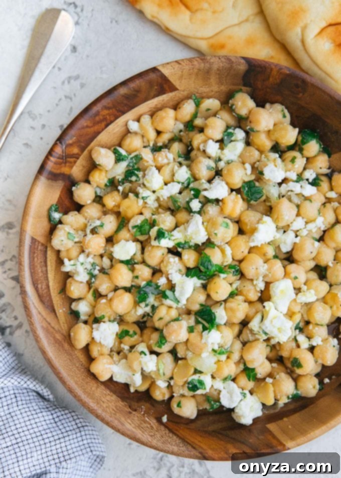 Mediterranean Chickpea & Feta Salad 4 A beautifully presented chickpea salad recipe with feta and lemon vinaigrette in a rustic wood bowl, showcasing its Mediterranean appeal.