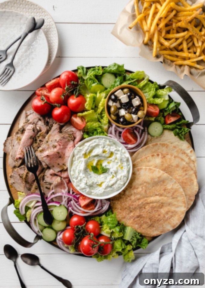 An inviting overhead view of a rustic round board laden with all the vibrant components for building delicious lamb pitas, including fresh vegetables, sauces, and thinly sliced succulent meat.