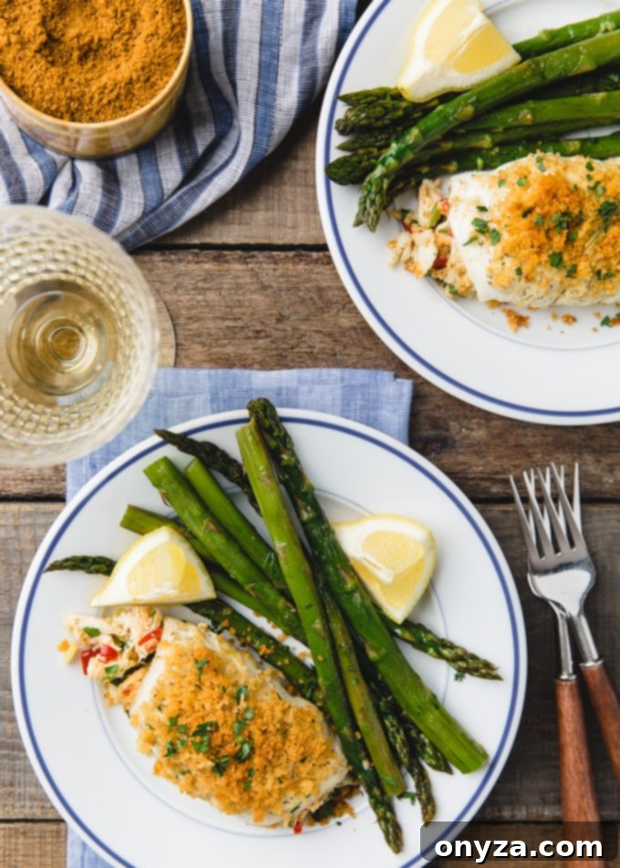 Overhead shot of two plates of crab stuffed flounder with fresh asparagus, showcasing an elegant meal. Sponsored content.