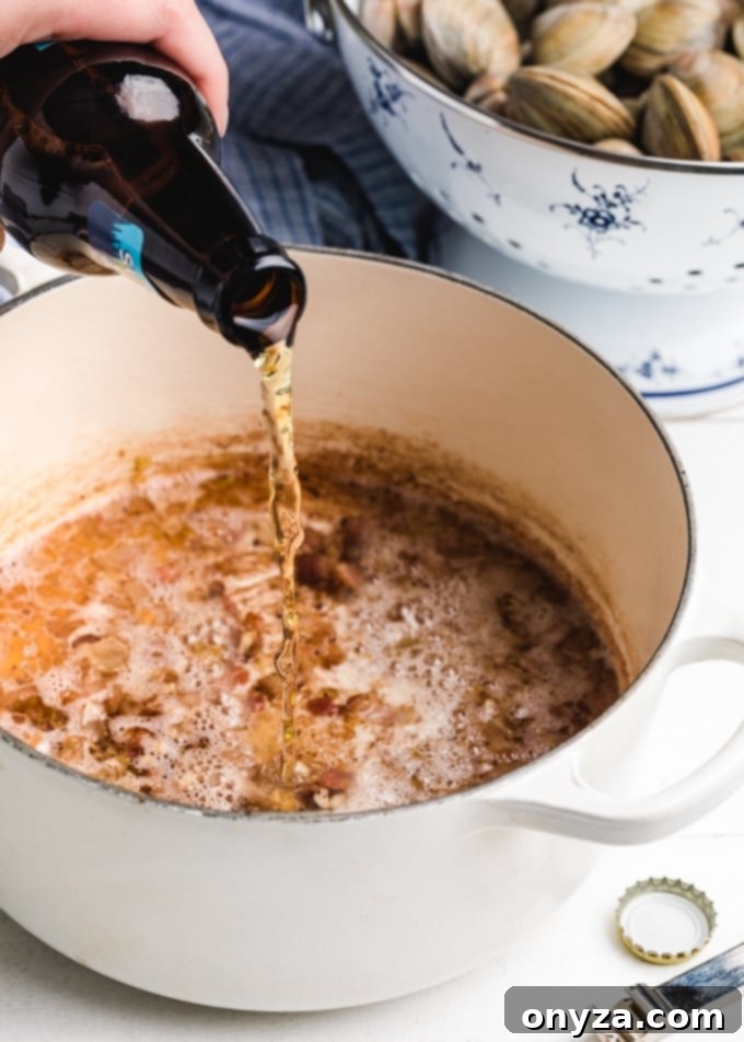beer being poured into a pot of sauteed bacon