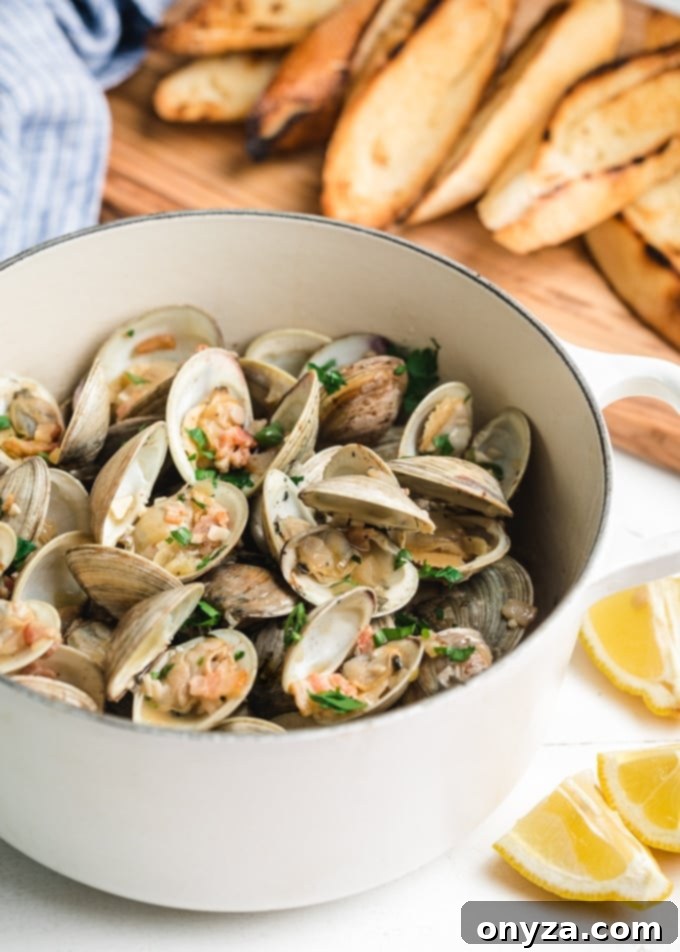 beer steamed clams with bacon in a white cast iron pot