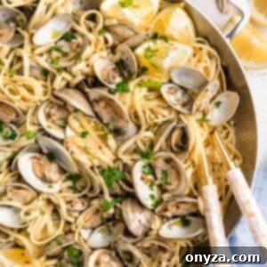 overhead of linguine with clams in a stainless steel pan