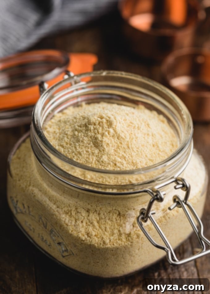 Golden organic cornmeal, showcasing its natural color and fine texture, stored in a clear glass jar.