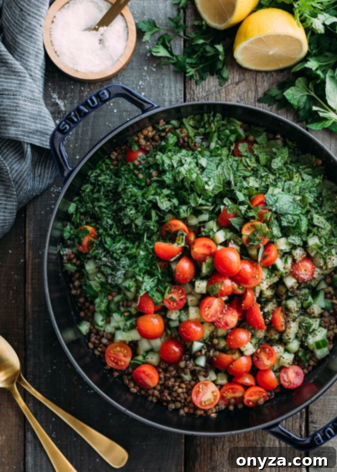 cherry tomatoes, chopped herbs, and french lentils in a cast iron pot