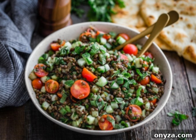 lentil tabbouleh in an ivory bowl with gold serving utensils