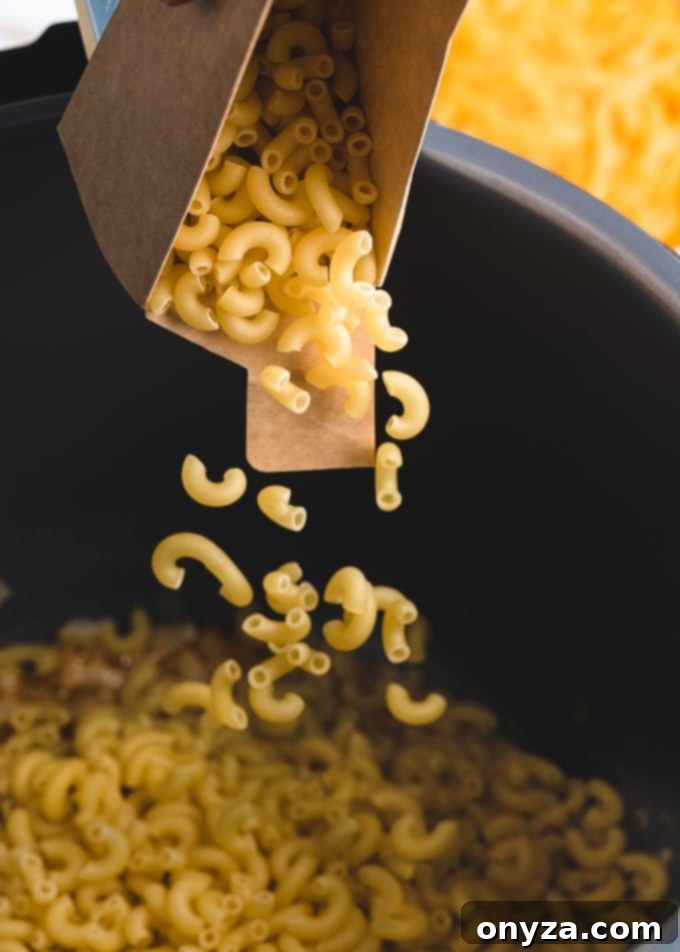 Instant Pot Mac and Cheese Four Irresistible Styles 5 elbow macaroni being poured from a box into an Instant Pot